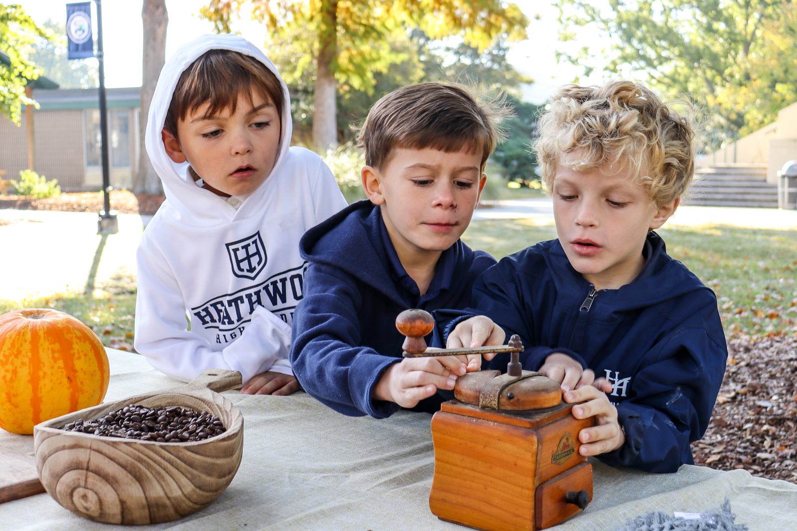 Students operating a manual coffee grinder